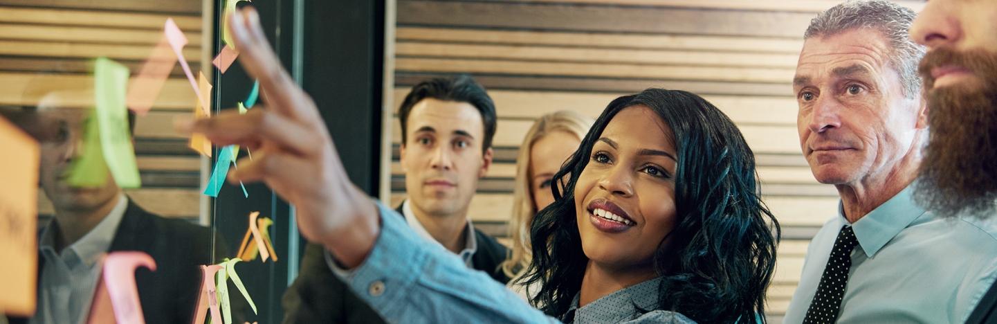 A group of people looking at sticky notes