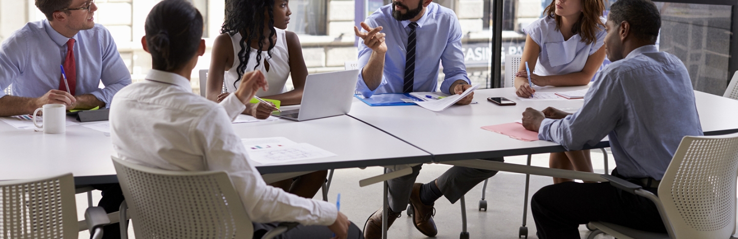 Business professionals gather around a table 