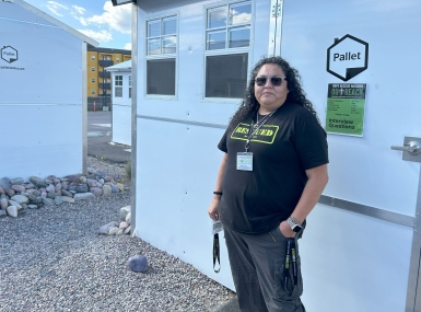 April Seat, director of Outreach for Hope Rescue Mission, shows off a pallet shelter in the Missoula County TSOS. Photo by Charlie Ban