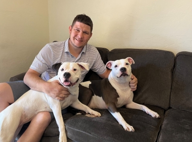 Phillip Bernard with dogs Xena and Harmonia: “I don’t know where I’d be without OPCS, probably in prison. They laid out the foundation for me to be where I am today.” Since getting connected to Housing First, he is sober, studying for his GED and taking computer programming classes.