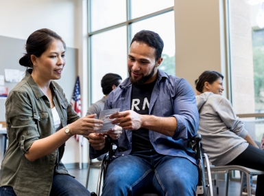 Woman and army vet in wheelchair review handout