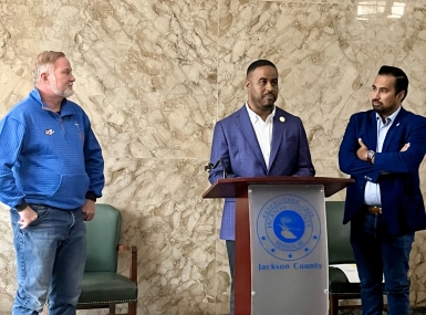 DaRon McGee speaks at a press conference flanked by Jackson County legislator colleagues Sean Smith (left) and Manuel Abarca.