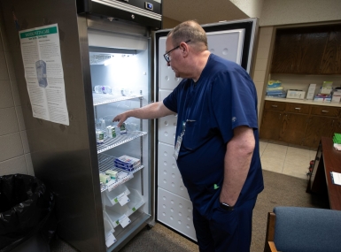 Andrews County Health Department director Gordon Mattimoe looks over the supply of refrigerated measles vaccines at the old City Hall building in Andrews, Texas. Photo by Mark Rogers for The Texas Tribune