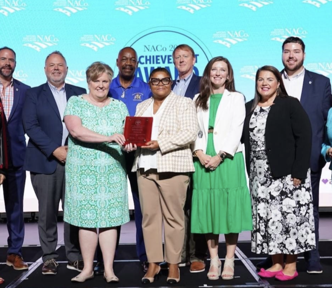 Then-NACo President Mary Jo McGuire of Ramsey County, Minn. (far left) pauses for a photo with Guilford County, N.C. staff after announcing their win July 14 in the Best in Category NACo Achievement Award in the Human Services category, at the NACo Annual Conference in Hillsborough County, Fla. Photo by Denny Henry