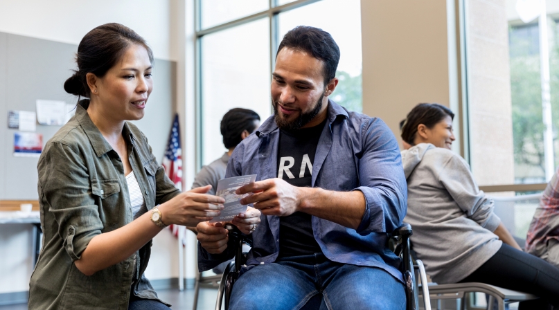 Woman and army vet in wheelchair review handout